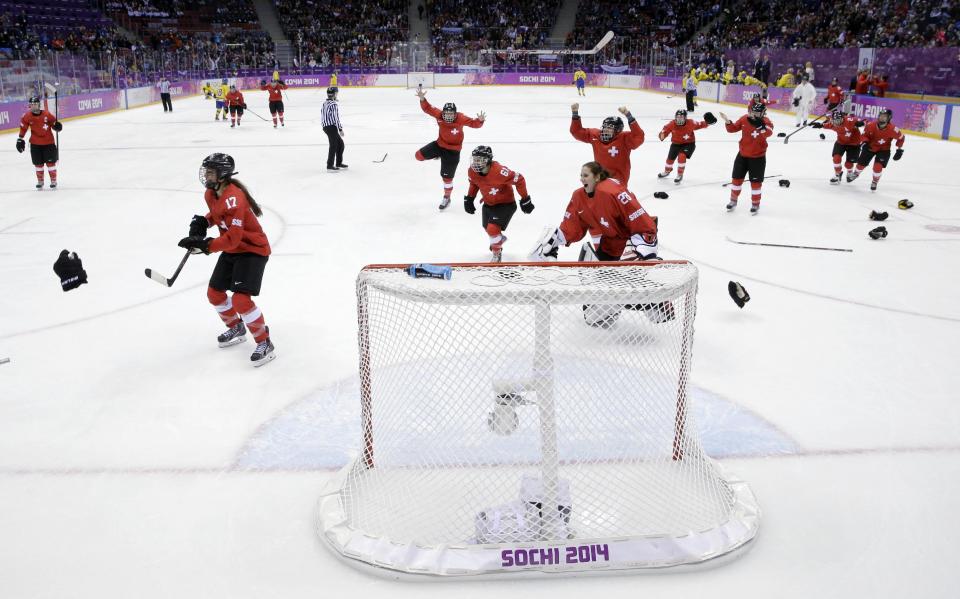 Switzerland players react after winning the women's bronze medal ice hockey game against Sweden at the 2014 Winter Olympics, Thursday, Feb. 20, 2014, in Sochi, Russia. Switzerland won 4-3. (AP Photo/David J. Phillip )