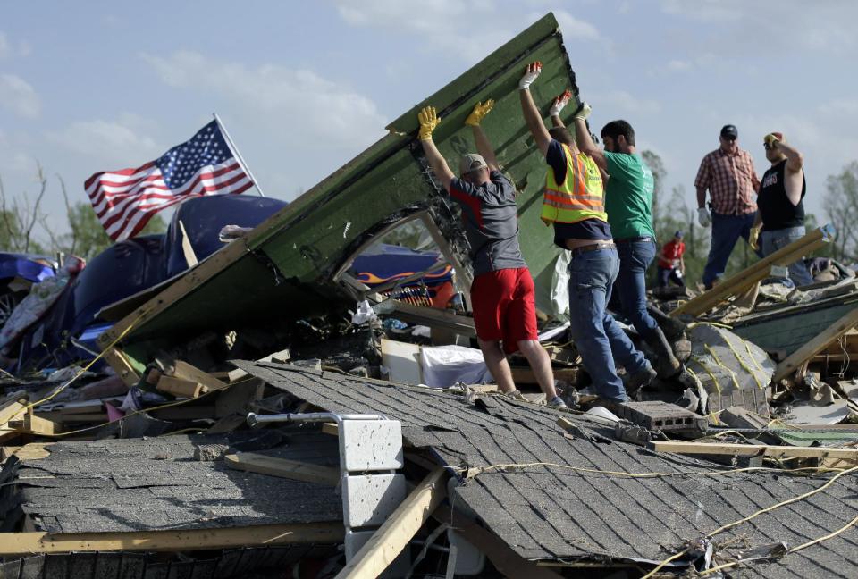 Friends and family sift through debris at the home of Daniel Wassom after his house was destroyed by a tornado, Monday, April 28, 2014, in Vilonia, Ark. Wassom died in the tornado trying to shield a family member. (AP Photo/Eric Gay)