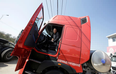 Sales manager Nie Liliang speaks while sitting in a liquefied natural gas (LNG) truck outside a heavy-duty truck shop in Yutian county, China's Hebei province September 29, 2017. REUTERS/Jason Lee