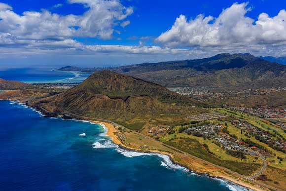 Aerial view of volcano crater near Honolulu, showing land and coastline.