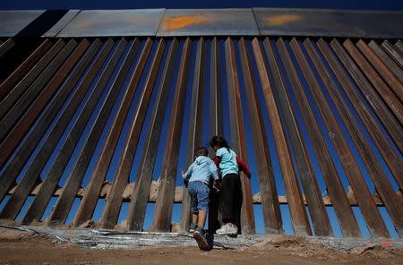 Niños juegan en un tramo recién construido de la cerca que separa a Ciudad Juárez en México y Sunland Park en Estados Unidos. 18 de noviembre de 2016. REUTERS/Jose Luis Gonzalez