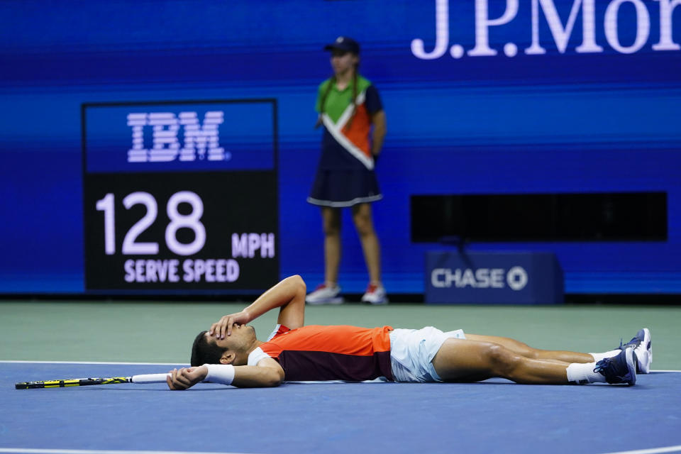 Carlos Alcaraz, of Spain, lies on the court after beating Jannik Sinner, of Italy, during the quarterfinals of the U.S. Open tennis championships, early Thursday, Sept. 8, 2022, in New York. (AP Photo/Frank Franklin II)