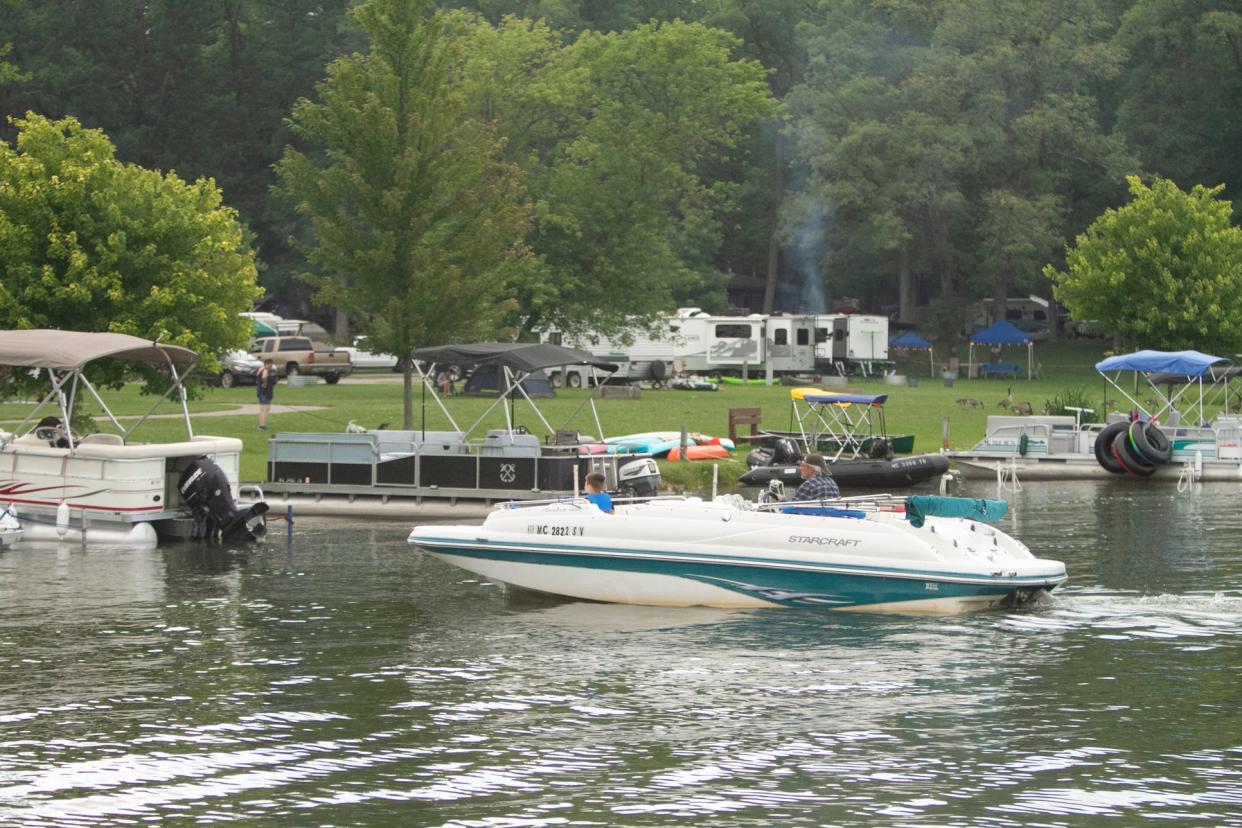 A boater heads toward shore to tie up at the Pinckney State Recreation Area's Bruin Lake modern campground Friday, July 9, 2021.