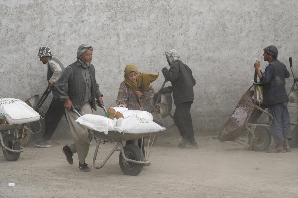 ARCHIVO - Varias personas reciben raciones de alimentos el 10 de mayo de 2022, en Kabul, Afganistán. (AP Foto/Ebrahim Noroozi, archivo)