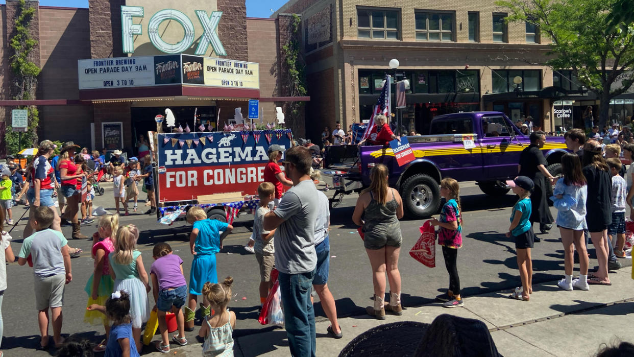 The float saying Hageman for Congress passes Casper's main street Fox cinema, as young bystanders cheer it on..