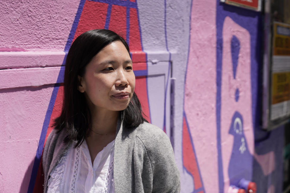 Jenny Leung, executive director of the Chinese Culture Center, poses by a new Chinatown mural in San Francisco, Monday, May 23, 2022. Chinatowns and other Asian American enclaves across the U.S. are using art and culture to show they are safe and vibrant hubs. "It was really, really important that the community was empowered and centered as a voice in the art because I think frequently the way that Chinatown looks is imported as a tourist kind of attraction and fantasy for visitors to see," Leung said. "It's never really about celebrating the community's perspective and voice." (AP Photo/Eric Risberg)