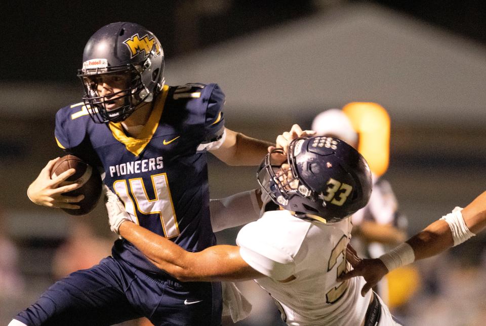 Mooresville High School's Levi Dorn (14)  keeps the ball from Decatur Central's Alberto Murillo (33) during the second half of the game Friday, Sept. 17, 2021, at Mooresville High School. The Decatur Central Hawks beat the Mooresville Pioneers 41-27.