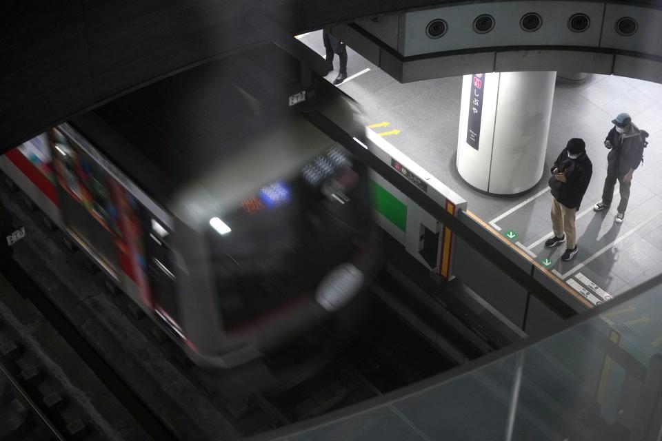 FILE - Passengers wait at platform for their train's arrival at Tokyu Railways' Shibuya Station, April 20, 2022, in Tokyo. Tokyu Railways’ trains running through Shibuya and other stations were switched to power generated by solar and other renewable sources. (AP Photo/Eugene Hoshiko, File)