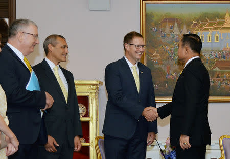 Richard Harris, Australian member of the Thai cave rescue team shakes hands with Thailand's Prime Minister Prayuth Chan-ocha, as he stands next to Craig Challen after receiveing the Member of the Most Admirable Order of the Direkgunabhorn award at the Government House, in Bangkok, Thailand, April 19, 2019. Thailand Government House/Handout via REUTERS