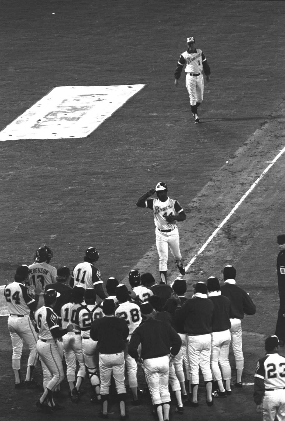 Atlanta Braves’ Hank Aaron tips his hat to teammates greeting him at home plate after hitting his 715th career home run during a baseball game against the Los Angeles Dodgers in Atlanta, Monday, April 8, 1974. (AP Photo/Joe Sebo, File)