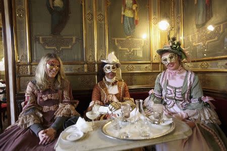 Masked revellers pose inside Caffe' Florian coffee shop in Saint Mark's Square during the Venetian Carnival in Venice in this February 27, 2011 file photo. REUTERS/Manuel Silvestri/Files