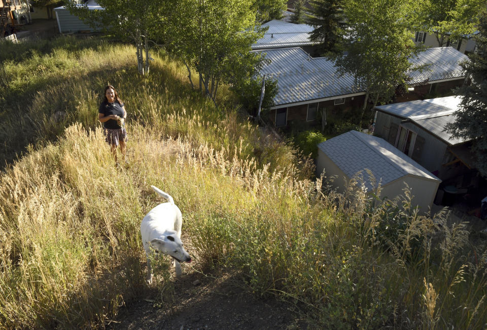 ADVANCE ON THURSDAY, SEPT. 12 FOR USE ANY TIME AFTER 3:01 A.M. SUNDAY SEPT 15 - Pitkin County Commissioner Patti Kay-Clapper walks with her dog near her home at the Smuggler Trailer Court outside Aspen, Colo., on Tuesday, Aug. 27, 2019. Clapper says that in the early 1980s, the county allowed Smuggler residents to own their homes and their lots in an effort to keep the community affordable. She now is trying to preserve the county's remaining mobile home parks as affordable housing. (AP Photo/Thomas Peipert)