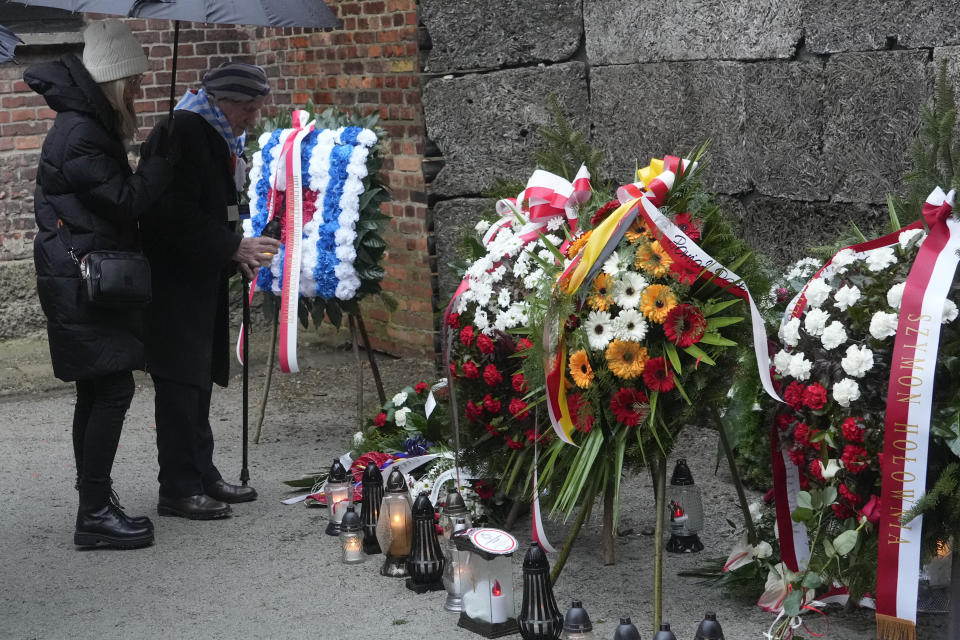 Holocaust survivors and relatives place candles next to the Death Wall in the Auschwitz Nazi death camp in Oswiecim, Poland, Saturday, Jan. 27, 2024. Survivors of Nazi death camps marked the 79th anniversary of the liberation of the Auschwitz-Birkenau camp during World War II in a modest ceremony in southern Poland.(AP Photo/Czarek Sokolowski)