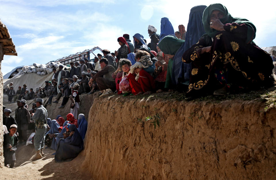 Survivors wait to receive food donations near the site of Friday's landslide that buried Abi-Barik village in Badakhshan province, northeastern Afghanistan, Tuesday, May 6, 2014. Authorities tried to help families displaced by the torrent of mud that swept through Abi-Barik village after hundreds were killed. (AP Photo/Massoud Hossaini)