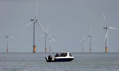 Two fishermen sit in their boat at the Gunfleet Sands Offshore Wind Farm near Clacton-on-Sea, Britain, May 16, 2014. REUTERS/Suzanne Plunkett/File Photo