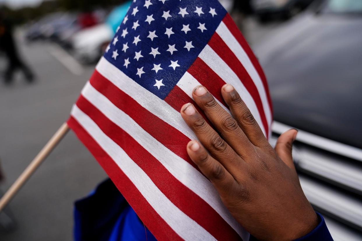 <span>A young child holds an American flag during a campaign rally in Marietta, Georgia.</span><span>Photograph: Brynn Anderson/AP</span>