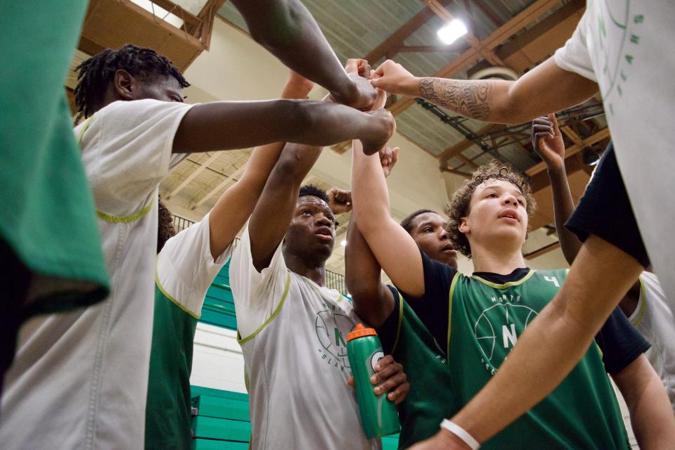 Amos Poe (center, holding bottle) breaks a huddle with his teammates during a Des Moines North practice on Feb. 7. Poe has been a one of the leaders for the Polar Bears on and off the court.