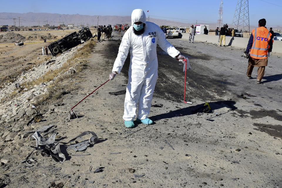 Investigators collect evidence at the site of a suicide bombing on the outskirts of Quetta, Pakistan, Wednesday, Nov. 30, 2022. A suicide bomber blew himself up near a truck carrying police officers on their way to protect polio workers outside Quetta, killing few people and wounding more than 20 others, mostly policemen, officials said. (AP Photo/Arshad Butt)