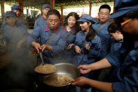 Participants dressed in replica red army uniforms distribute food during a Communist team-building course extolling the spirit of the Long March, organised by the Revolutionary Tradition College, in the mountains outside Jinggangshan, Jiangxi province, China, September 14, 2017. REUTERS/Thomas Peter