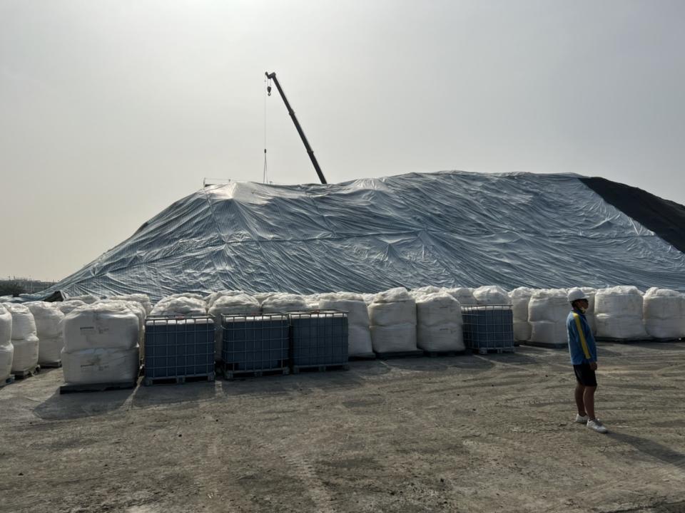 下方太空包為生物製劑，用於執行污染土方生物復育，後面覆蓋防塵網，維持空氣品質。   圖：高雄市環保局提供