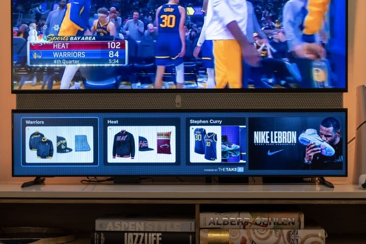 Opportunities to purchase sports gear are seen beneath an NBA game.