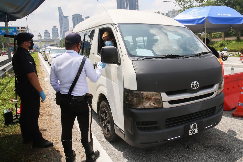 Police conduct checks on vehicles at a roadblock on the Federal Highway on the first day of Raya May 13, 2021. — Picture by Choo Choy May