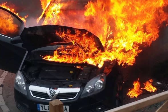 Lisa Taperek's photo which captures the dramatic moment her Vauxhall Zafira burst into flames. See SWNS story SWFLAMES; A mother rescued her ten-month-old baby from her smoking car just seconds before it burst into flames, as the Vauxhall Zafira combustion scandal continues. Mum-of-four Lisa Taperek, 32, only noticed something was wrong with her 2007 Zafira B when her mother saw smoke billowing out of the engine bay. No sooner had she popped open the bonnet to inspect the engine than she realised there was no time to spare, and snatched her baby son, Kinsley, from his car seat. "I was faffing about in my bag when mum walked down the drive to the car, opened up the door and said 'why is the car smoking?' I hadn't even noticed it," she said.