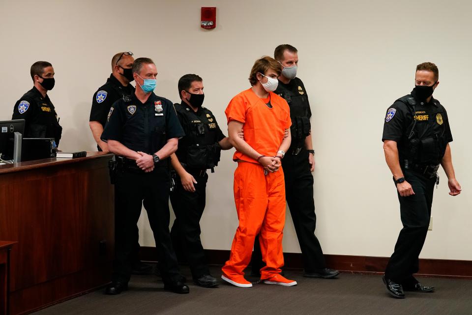 The man accused in racist mass shooting at a Buffalo, N.Y., supermarket, is led into the courtroom for a hearing at Erie County Court in May.