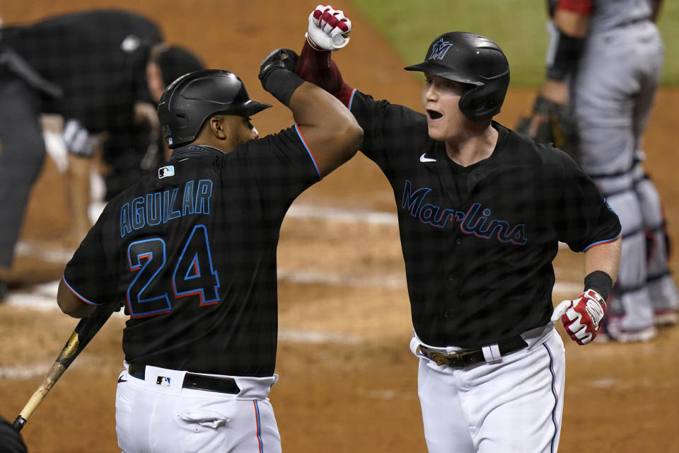 Miami Marlins' Garrett Cooper, right, celebrates with Jesus Aguilar (24) after hitting a two-run home run during the third inning of the team's baseball game against the Washington Nationals, Saturday, Sept. 19, 2020, in Miami. (AP Photo/Lynne Sladky)