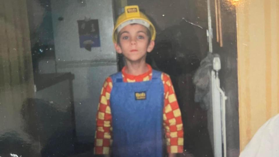 Justin Lewis as a child dressed as Bob the builder