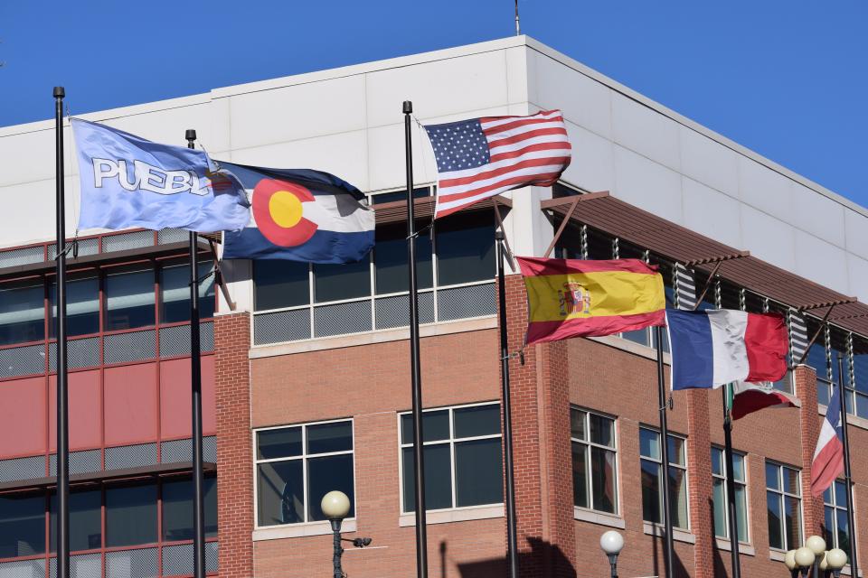The Pueblo city flag (far left) sits beside the state flag of Colorado and the national flags of the United States, Spain and France in downtown Pueblo in December 2023.