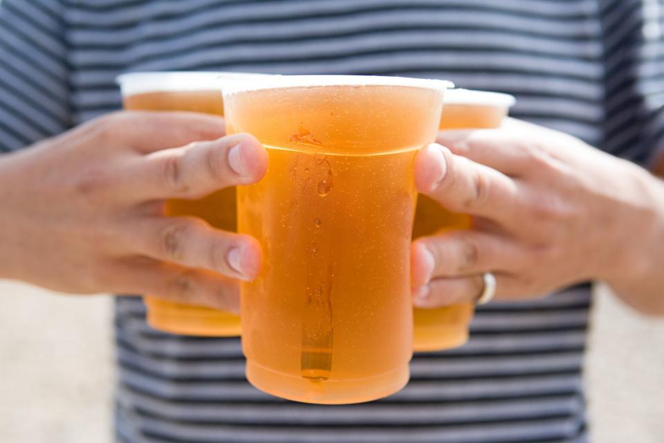 <p>Getty</p> Stock photo of a man holding a trio of beers.