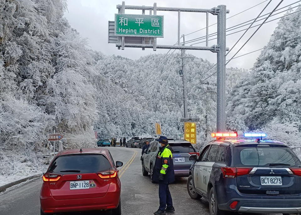 台七甲線四十五點七公里處降下瑞雪，和平警分局員警置身其中指揮交通。（記者陳金龍翻攝）