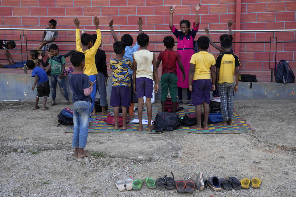 A teacher conducts an after school class, part of a program run by a non-government organization for migrant children, many of whom are climate refugees, in Bengaluru, India, Thursday, July 21, 2022. (AP Photo/Aijaz Rahi)