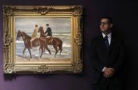 A security guard stands near "Zwei Reiter am Strand mach links (Two Riders on a Beach)" by Max Liebermann at Sotheby's in London, Britain June 19, 2015. REUTERS/Suzanne Plunkett