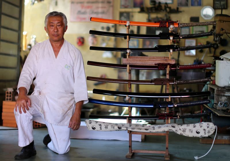 Samurai Suemitsu poses for pictures next to katana swords at his home in Curitiba