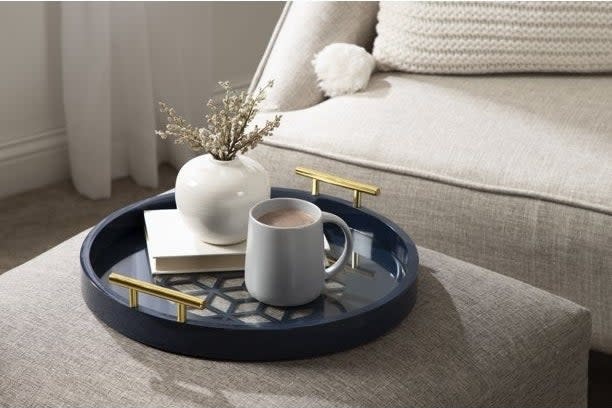 A serving tray holds coffee and a plant