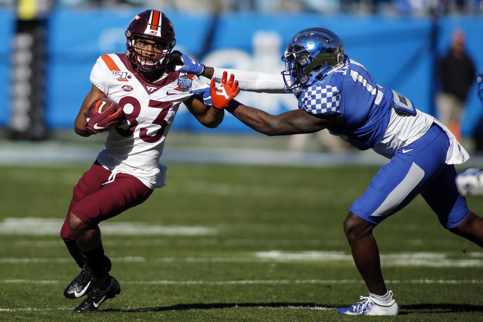 Virginia Tech wide receiver Tayvion Robinson, left, fights for yardage against a Kentucky defender during the first half of the Belk Bowl NCAA college football game in Charlotte, N.C., Tuesday, Dec. 31, 2019. (AP Photo/Nell Redmond)