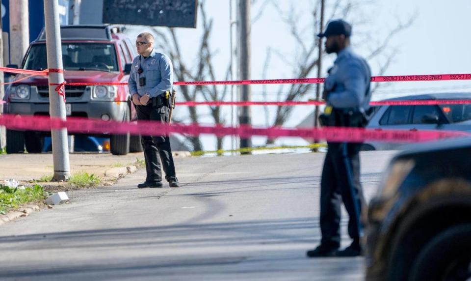 Police stand near the scene where three officers were shot Wednesday in Kansas City, Kansas.