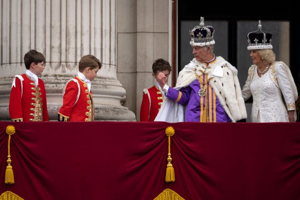 King Charles gestures to Prince George on the balcony of Buckingham Palace after the coronation.