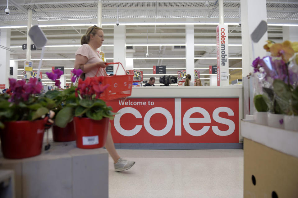 Pictured: Shopper walks with grocery basket in Coles supermarket. Image: Getty