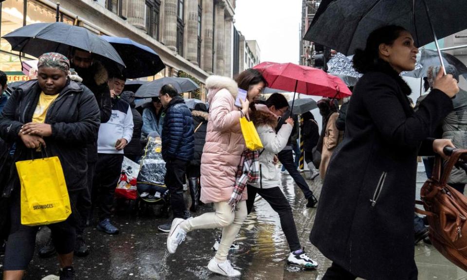 Shoppers jump over puddles of water as they hunt for bargains during the Boxing Day sales in central London.