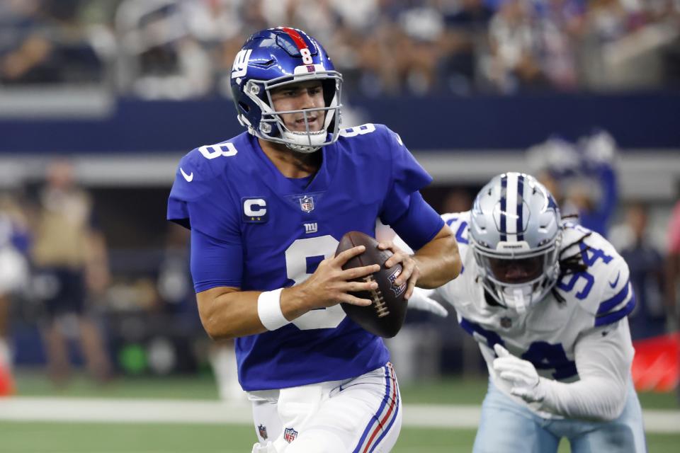 New York Giants quarterback Daniel Jones (8) scrambles out of the pocket under pressure from Dallas Cowboys defensive end Randy Gregory (94) in the first half of an NFL football game in Arlington, Texas, Sunday, Oct. 10, 2021. (AP Photo/Ron Jenkins)