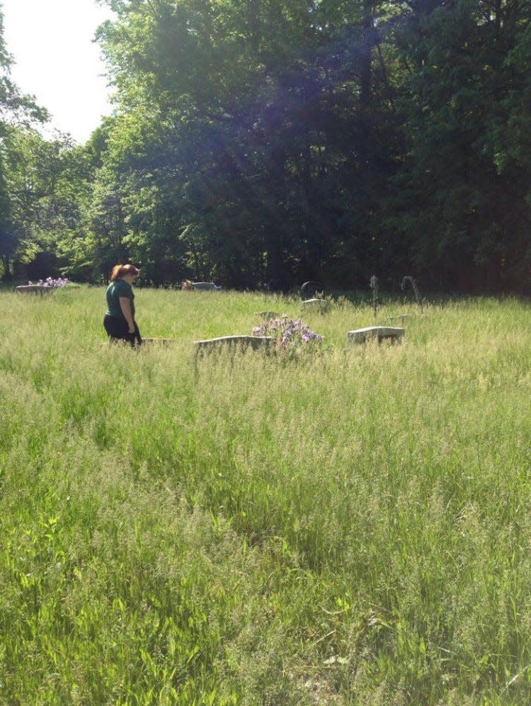 Sue Faulk's daughter Sierra Cross surveyed the cemetery before her mother mowed the grass that had grown over stones.