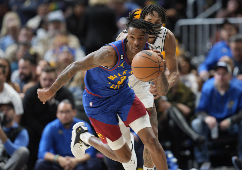 Denver Nuggets guard Bones Hyland, front, collects the ball in front of San Antonio Spurs guard Devin Vassell in the second half of an NBA basketball game Saturday, Nov. 5, 2022, in Denver. (AP Photo/David Zalubowski)