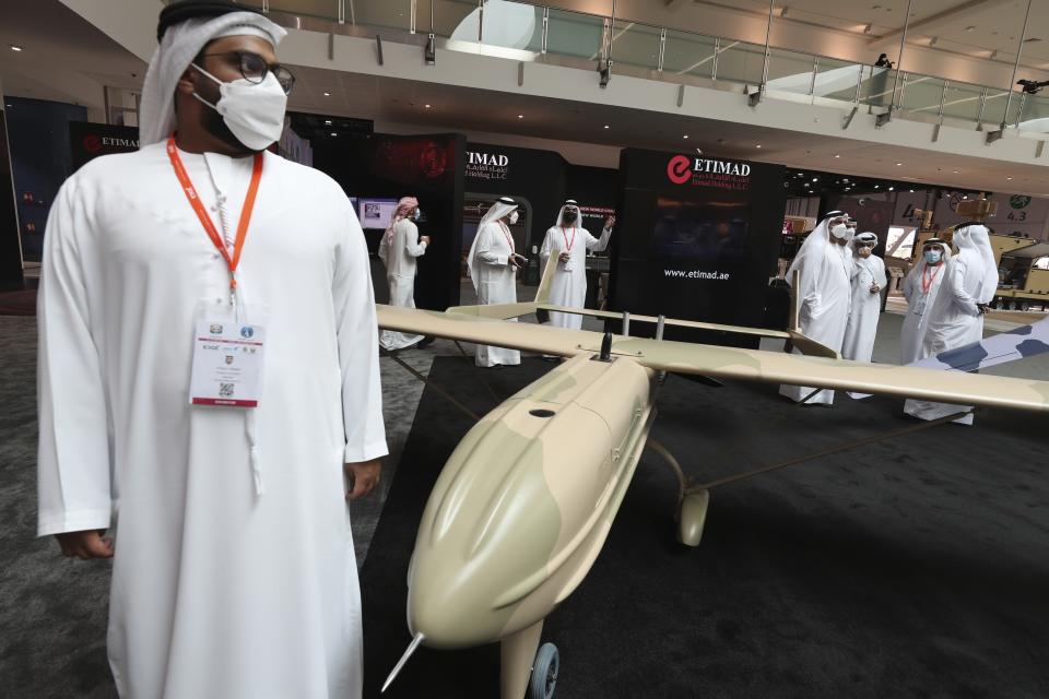 Visitors and officials pass by a combat drone from Etmad, an Emirati company, during the opening day of the International Defence Exhibition & Conference, IDEX, in Abu Dhabi, United Arab Emirates, Sunday, Feb. 21, 2021. (AP Photo/Kamran Jebreili)