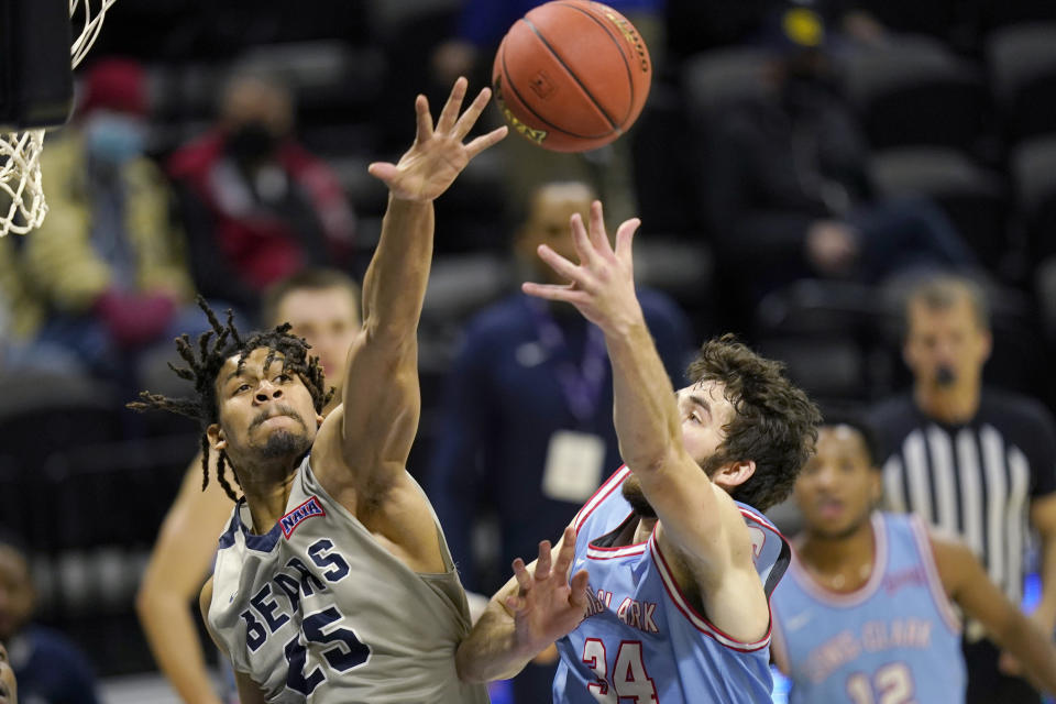 Lewis-Clark State forward Jake Albright (34) shoots while covered by Shawnee State forward Latavious Mitchell (25) during the first half of the NAIA men's college basketball tournament final in Kansas City, Mo., Tuesday, March 23, 2021. (AP Photo/Orlin Wagner)