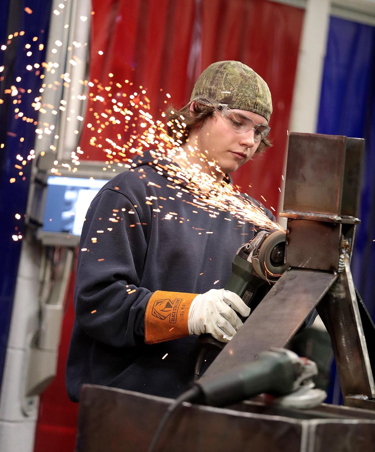 Travis Pitts, a senior from Minerva High, uses a grinder while constructing a box blade for a plow during his class at R.G. Drage Career Technical Center in Massillon. The school offers 20 programs from welding to animal sciences pre-veterinary technology.