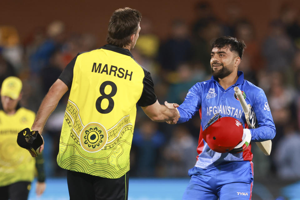 Australia's Mitchell Marsh, left, shakes hands with Afghanistan's Rashid Khan following the T20 World Cup cricket match between Australia and Afghanistan in Adelaide, Australia, Friday, Nov. 4, 2022. (AP Photo/James Elsby)