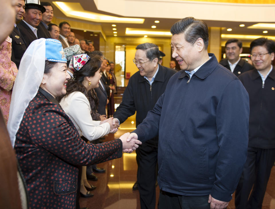 In this Wednesday, April 30, 2014 photo released by China's Xinhua News Agency, Chinese President Xi Jinping, front right,shakes hands with model workers and outstanding figures in Urumqi, capital of northwest China's Xinjiang Uygur Autonomous Region. Xi had an inspection tour in Xinjiang from April 27 to April 30. (AP Photo/Xinhua, Xie Huanchi) NO SALES